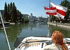 Im Wiener Donaukanal mit Blick auf die Urania : Motorboot, Flagge, Andrea Horn